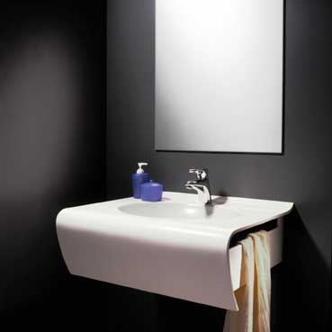 Klicken zum vergrößern! Mit schwungvoller Linienführung präsentiert sich der Waschtisch „ARTELIO® swing“. Der aus Wilsonart® – Mineralstoff in 13 mm Stärke geformte Solitär vereint alle Eigenschaften eines eleganten Blickfangs. Die fugenlose und pflegeleichte Oberfläche formt ein Becken, das mit einer verdeckten Installation der Anschlüsse auch funktionelle Vorgaben einlöst. Foto: Resopal